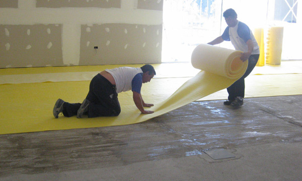 Extienda y presione fuertemente el Base para Alfombras ISOLANT contra el piso para evitar que queden pliegues o partes sin adherir.